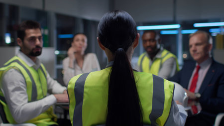 Back view of female engineer leading meeting with contractors in modern officeの写真素材