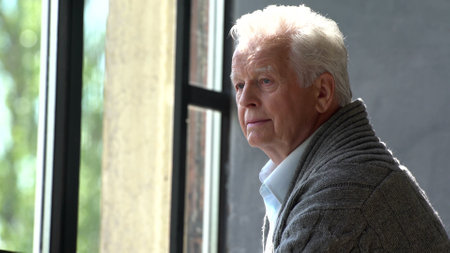 Elderly caucasian man look at window lost in thought