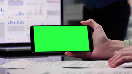 Close up of businesswoman work with documents using smartphone with green screen