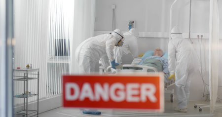 Doctors wearing ppe suit moving patient to emergency room in hospitalの写真素材