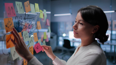 Side view of African-American businesswoman brainstorm and stick notes to glass boardの写真素材