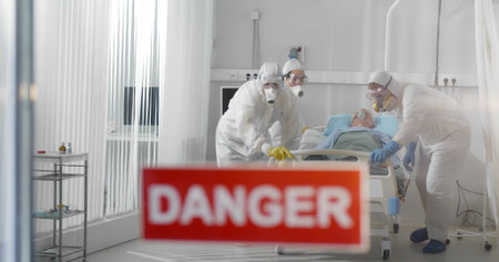 Infected patient lying in bed in quarantine hospital wardの写真素材