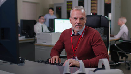 Portrait of mature businessman sitting at desk and smiling at cameraの写真素材