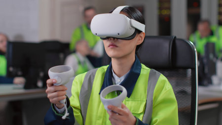 Young woman engineer test vr goggles and controllers in modern industrial laboratoryの写真素材