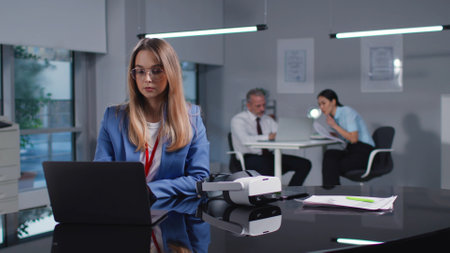 Young woman in smart casual sit at desk and use computerの写真素材
