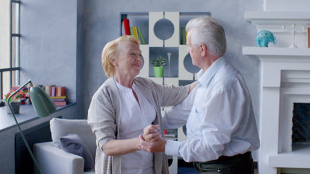 Happy elderly couple dancing at homeの写真素材