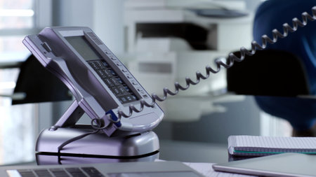 Cropped shot of secretary using stationary phone talking to bossの写真素材
