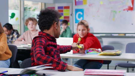 Teen girl pass note to classmate during exam in classroomの写真素材
