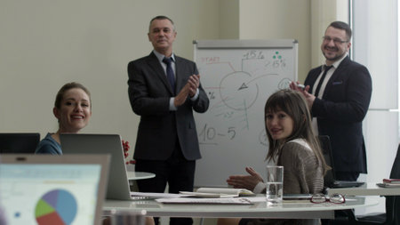 Cheerful business people smiling at camera and applauding at meeting