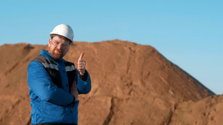 Construction worker in safety helmet looking at camera and showing thumbsupの写真素材