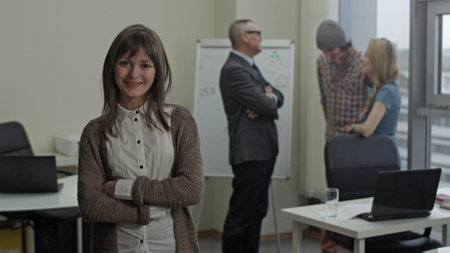 Portrait of smiling female employee posing at camera in officeの写真素材