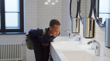 African-American teen student suffer from stomach ache having food poisoningの写真素材