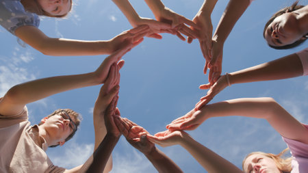Bottom view of group of high school students raise the shape of a circle created from their palms.の写真素材