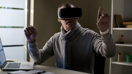 Mature male entrepreneur using 3d vr headset at his workplaceの写真素材