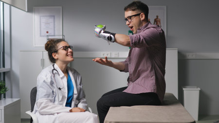 Woman physiotherapist exercises wit patient with hand prosthesis in medical office.の写真素材