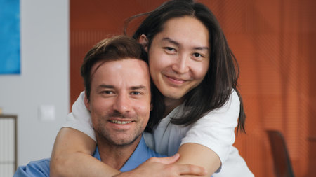 Close up of asian man hug boyfriend from behind sitting on couch