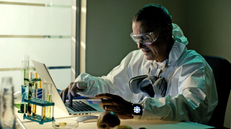Medical scientist working on laptop doing research in laboratoryの写真素材