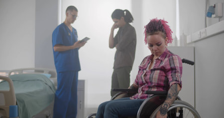 Upset disabled young woman in wheelchair with doctor and husband talking on background