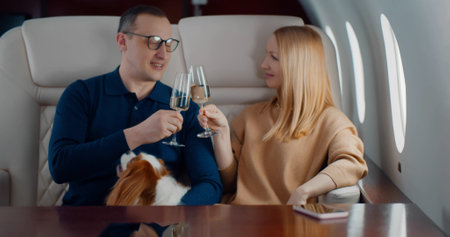 Couple with dog in private jet drinking champagneの写真素材
