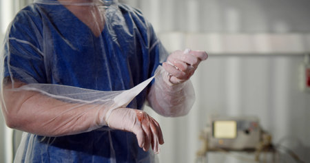 Closes up of surgeon putting off dirty gloves after surgeryの写真素材
