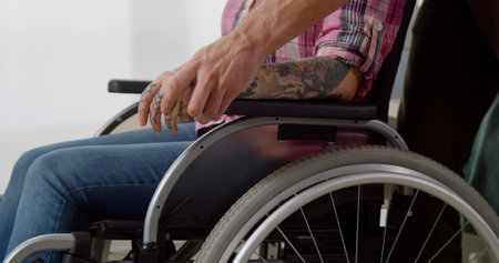 Cropped shot of disabled woman in wheelchair holding boyfriend handの写真素材