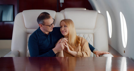 Happy couple hugging and relaxing travelling in private jetの写真素材