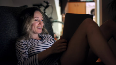 Experience a Joyful and Relaxing Evening at Home while Using Your Laptop in Comfortの写真素材