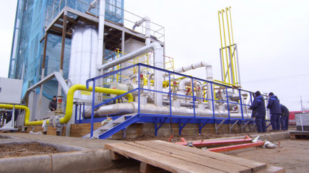 Workers paint ladder in large industrial complexの写真素材