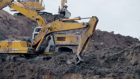 Large construction yellow excavators on construction site in quarry