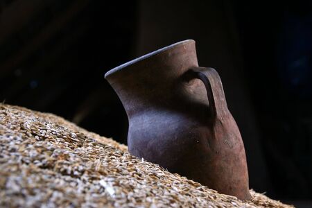 On a heap of grain the old jug liesの写真素材