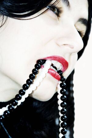 The nice girl holds a beads in a mouthの写真素材