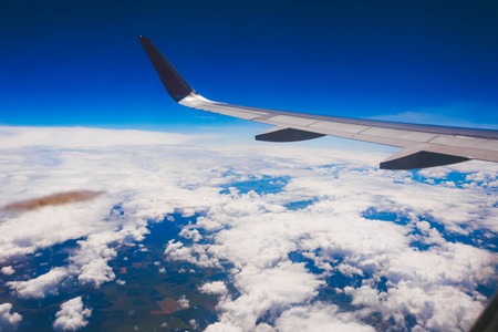 Plane wing in flight on blue sky background.の写真素材