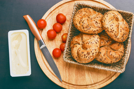 Breakfast served. Cooked buns with cherry tomatoes and melted cheese on the table.の写真素材