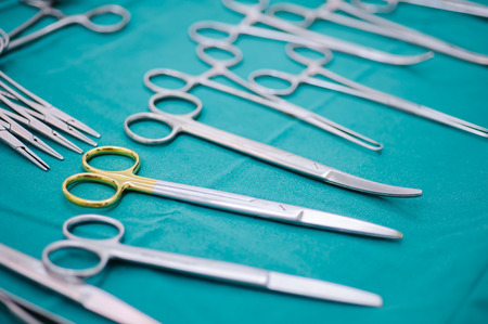 Detail shot of steralized surgery instruments with a hand grabbing a tool