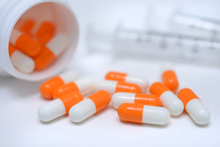 Syringes and capsules on white background.の写真素材