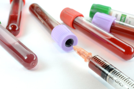 Syringe and blood test tube on white background.の写真素材