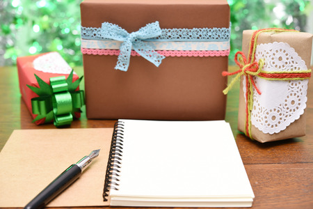 open notebook and gift box on green background.の写真素材