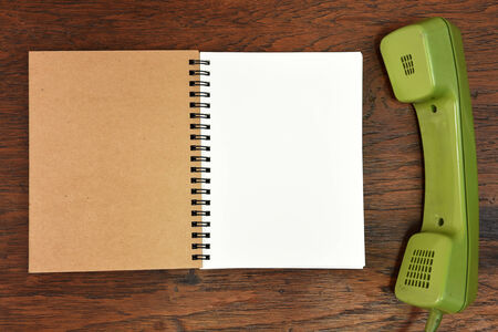 Vintage rotary telephone and notebook on wooden background.の写真素材