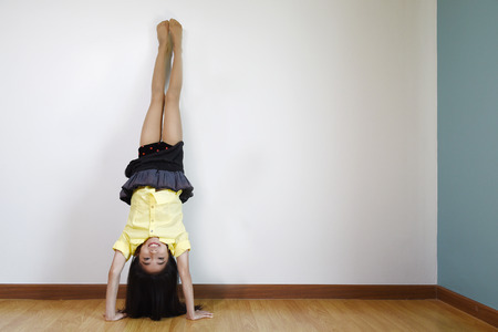 Cute little girl standing on her hands.