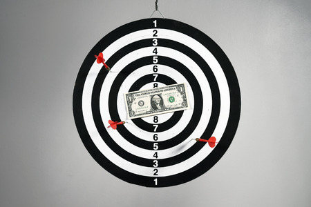 One dollar bill on a dartboard.の写真素材