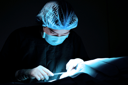 veterinarian doctor in operation room for surgical take with blue filterの写真素材