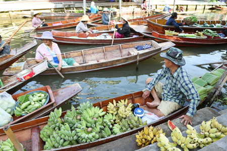 AMPHAWA ? APRIL 29: Wooden boats are loaded with fruits from the orchards at Tha kha floating market on April 29, 2015 in Amphawa. A traditional way still practiced in Tha kha canals of Thailand.のeditorial素材
