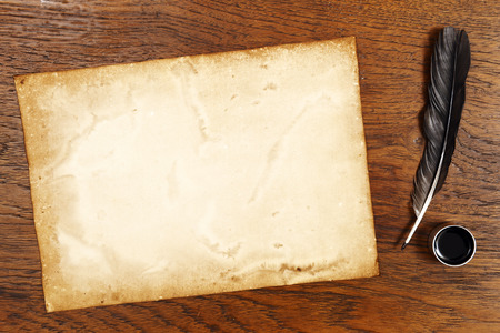 old paper on brown wood texture with feather and ink.の写真素材