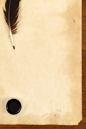 old paper on brown wood texture with feather and ink.の写真素材