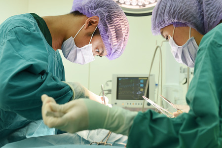two veterinarian surgeons in operating roomの写真素材