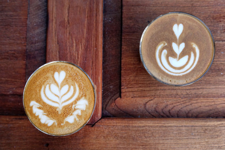cup of latte art coffee on wooden backgroundの写真素材