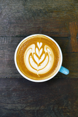cup of latte art coffee on wooden backgroundの写真素材