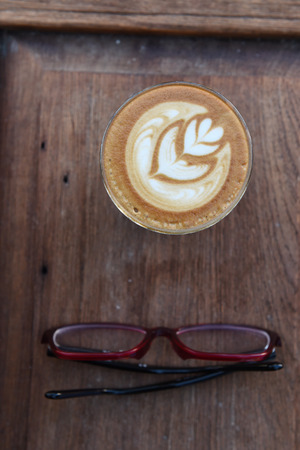cup of latte art coffee on wooden backgroundの写真素材