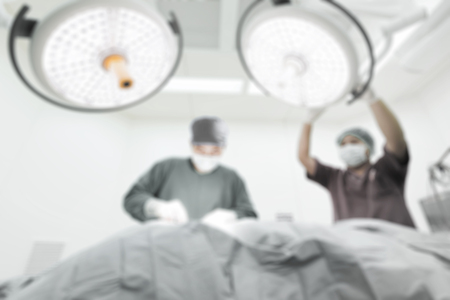 Blur of two veterinarian surgeons in operating room take with selective color technique and art lightingの写真素材