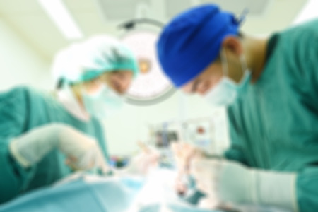 Blur of two veterinarian surgeons in operating roomの写真素材
